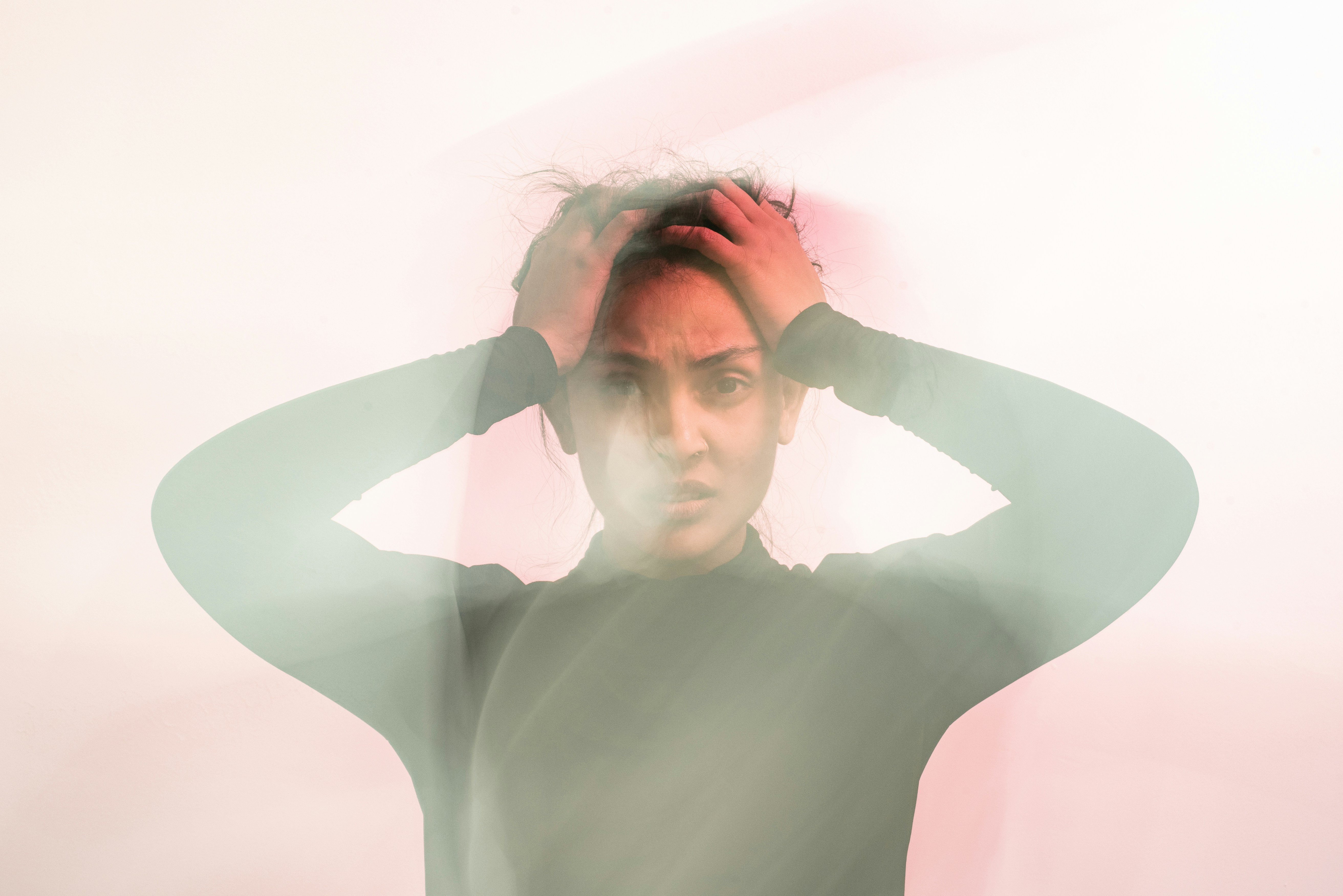 Person overwhelmed with hands on head